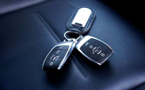 Two Mercedes Benz car keys resting on a luxurious leather seat, showcasing elegance and design.