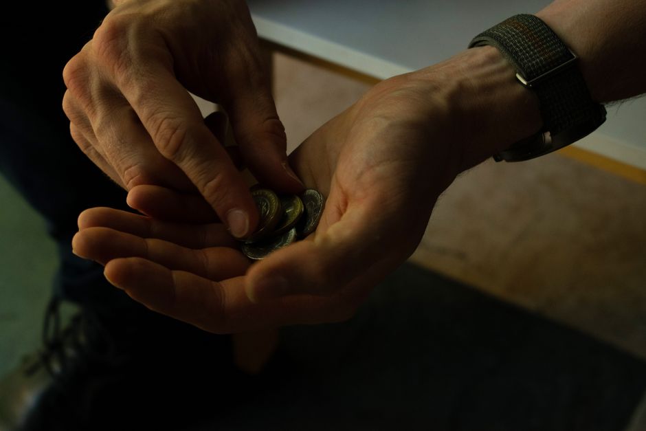 Close-up of hands counting coins, implying budgeting or financial planning.