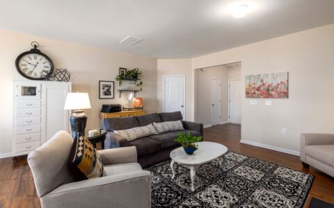 Spacious living room with modern decor, featuring a comfortable sofa and stylish accents.