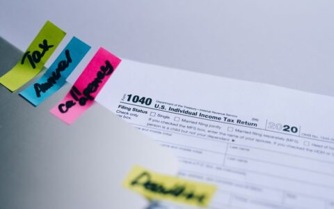 Close-up of 1040 U.S. tax form with colorful sticky notes for organization.